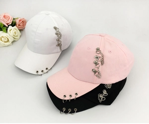 Close-up of three baseball caps in black, pink, and white with metal rings and chains