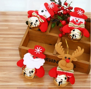 Close-up of plush Santa and Snowman figurines with golden metal bells on wooden box