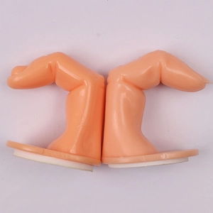 Detailed view of peach plastic nail practice fingers on stable white bases for manicures
