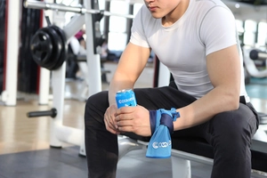 Detail of blue mesh cooling wristband worn during fitness training in gym setting