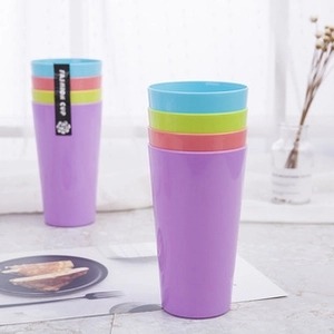 Detail of colorful stacking cups in purple and blue on marble background for kids