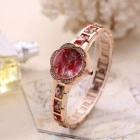Detail of rose gold quartz watch with red enamel dial on vintage script paper backdrop