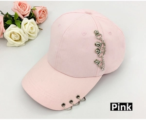 Close-up of pink baseball cap featuring metal rings and stylish chain detail