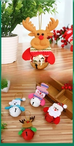 Detail of plush reindeer, snowman, and Santa bell ornaments hanging with golden strings