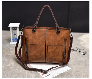 Brown vintage tote bag featuring dual front zipper pockets and removable shoulder strap