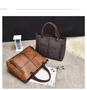 Detail view of retro tote bag sets in brown and grey with symmetric front pocket design