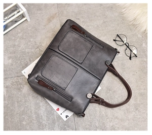 Detailed view of the retro dark grey oil leather tote bag with functional front pockets
