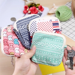 Close-up of assorted mini fabric coin purses with diverse prints and metal zipper rings
