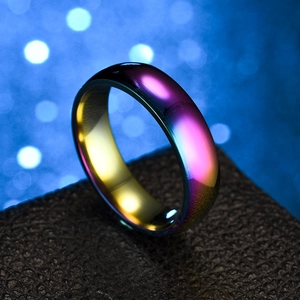 Macro shot of colorful gradient stainless steel ring on black textured background