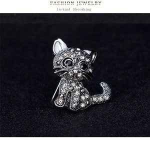 Detail view of retro cat brooch featuring sparkling rhinestones on black background