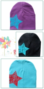 Detailed view of three knitted star beanies in purple, black and turquoise colors