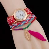 Detail of vintage cloisonné watch and woven charm bracelet with leaf and feather on wrist