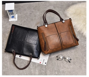 Detail view of retro faux leather tote bags in black and brown with metal hardware