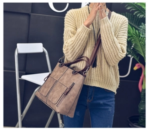Brown vintage PU leather tote bag styled on a white chair in a modern room setup
