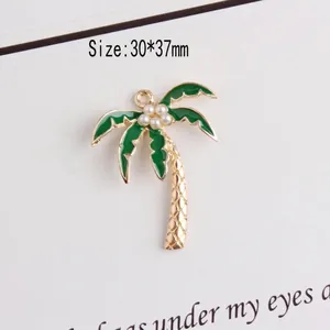 Detail of green enamel coconut tree pendant with pearls and gold plated alloy finish