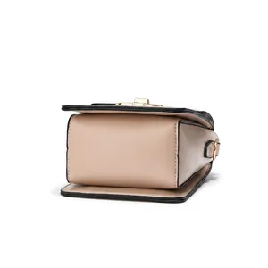 Detail view of pink-beige PU leather bag featuring gold hardware and black edge paint