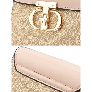 Detail of light gold metal twist lock closure on a pink leather and logo print handbag