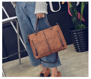 Brown vintage PU leather tote bag with dual handles and utility pockets shown by model