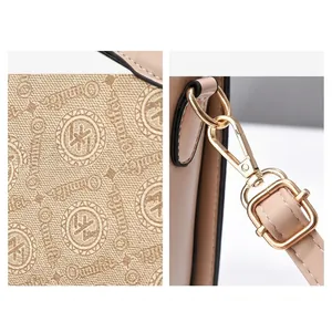 Detail of light brown leather bag showing canvas monogram pattern and gold metal hardware