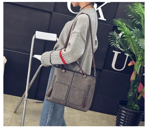 Gray vintage faux leather tote bag with dual zipper pockets shown worn as a crossbody bag