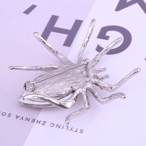 Back view of silver insect spider brooch with yellow crystal accents and pin closure
