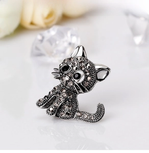 Detailed view of cat brooch with sparkling grey and black rhinestones on silver metal