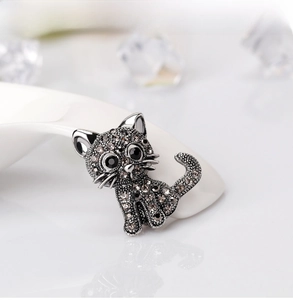 Detailed view of a vintage cat brooch with grey rhinestones and black crystal eyes