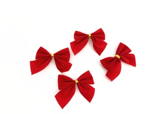Set of four red flocked Christmas bows with gold metallic twist ties on a white background