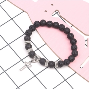 Detail of black lava stone yoga bracelet with silver beads and hollow cross charm