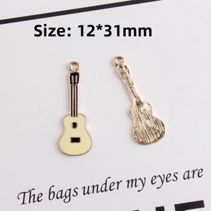 Macro view of 12*31mm enamel guitar charm with cream front and golden textured back