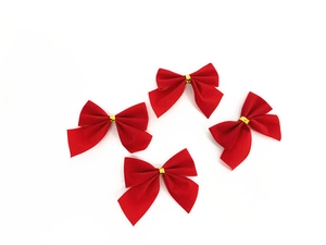 Close-up of four red flocked velvet Christmas bows with gold metallic twist ties