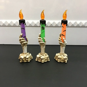 Close-up of Halloween LED candle lights with skeleton hand base and colorful glitter fill