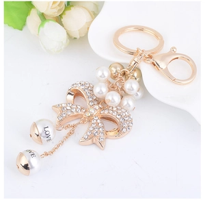 Detailed view of sparkling bowknot keychain with rhinestone inlay and LOVE pearl charms