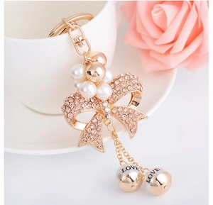 Macro view of crystal bow keychain with champagne rhinestones and LOVE charms