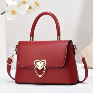 Elegant deep red leather handbag with gold heart-shaped buckle and matching chain detail