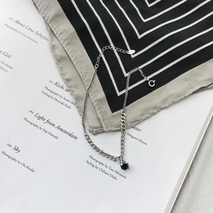 Detail of S925 sterling silver chain anklet with round black zircon pendant on silk