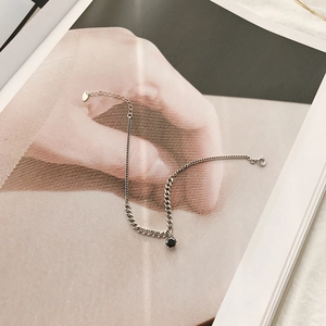Silver S925 sterling chain anklet with black zircon pendant on an artistic magazine