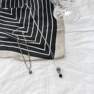 Close-up of S925 silver chain jewelry with black zircon stones on striped silk