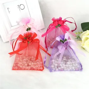 Detail of organza gift bags with drawstring and handmade rose knot in vibrant colors