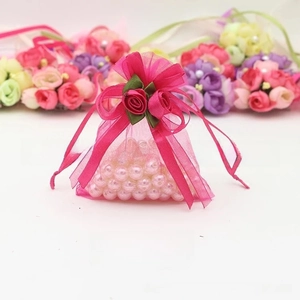 Close-up of rose red organza gift bag with ribbon bow and 3D decorative roses