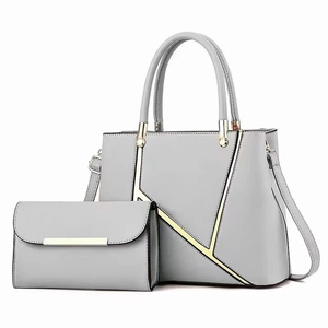 Light gray faux leather handbag set with geometric metal lines and gold hardware