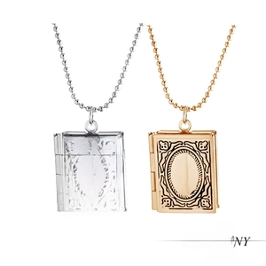 Detailed macro view of vintage book-shaped lockets with elegant embossed floral patterns