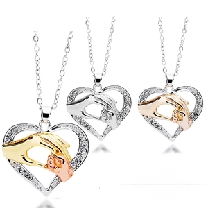 Close-up of heart-shaped floating locket charms with pavé crystals and family motifs
