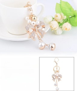 Detailed view of rhinestone bow keychain with pearls and love engraving for bags