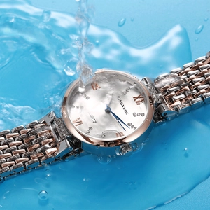 Close-up of diamond-set steel watch splashing in blue water showing waterproof feature