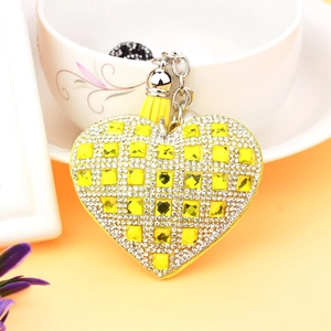 Detail of yellow heart crystal keychain with rhinestones and elegant leather fringe