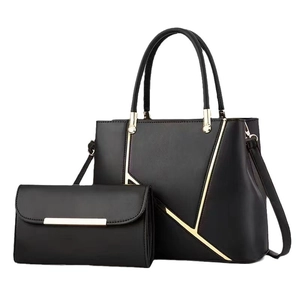 Modern black leather handbag and clutch set with golden metal accents on white background