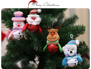 Detailed view of four festive Christmas plush bells hanging on a decorated tree