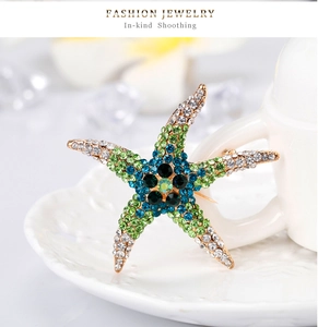 Macro detail of starfish brooch featuring colorful rhinestones on gold-toned metal base