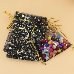 Close-up of black mesh drawstring pouch with gold and silver stars filled with beads